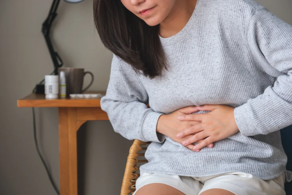 adult woman feeling pain with hands on stomach 2026 03 16 01 20 42 utc