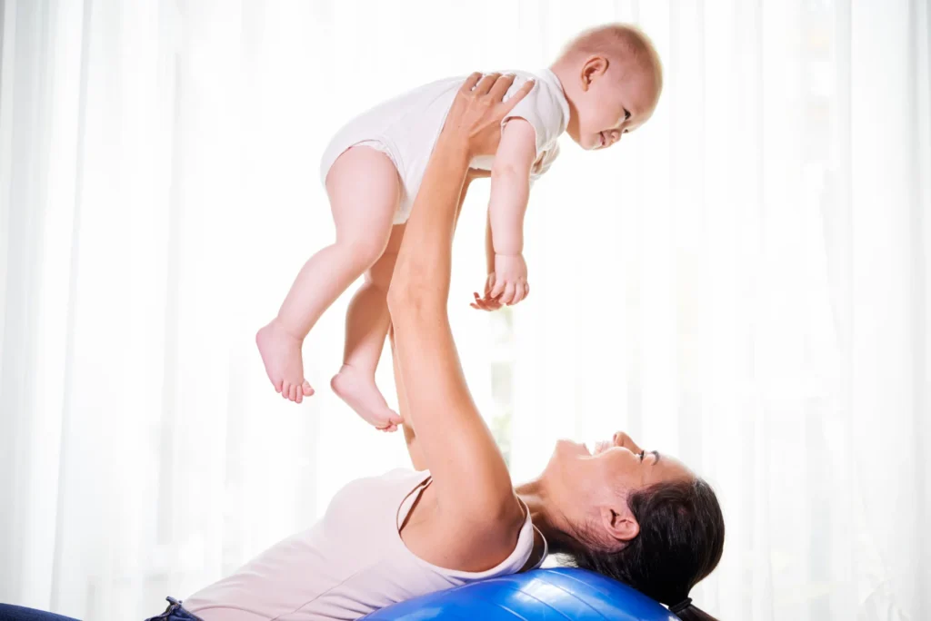 woman lifting baby while laying on exercise ball 2026 01 07 07 00 35 utc